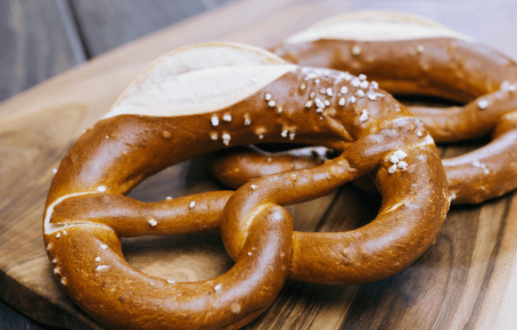 2 Laugenbrezeln auf einem Holzbrett